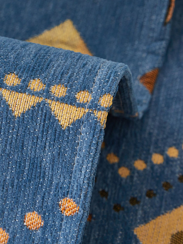 Close-up of blue fabric with yellow geometric patterns
