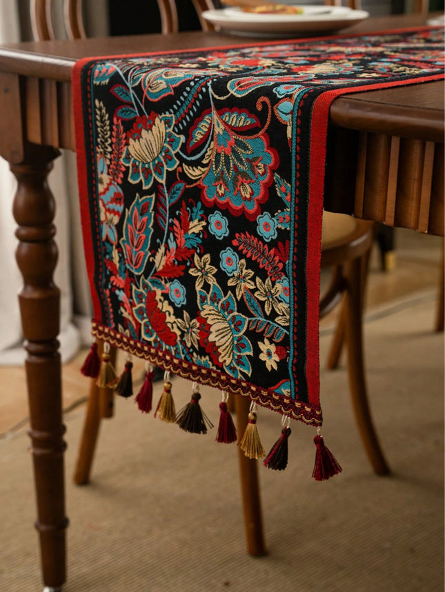 Decorative table runner with intricate patterns and tassels on a wooden table.