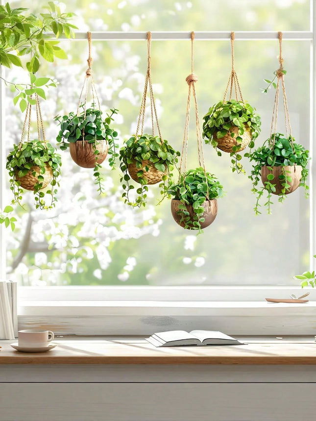 Hanging plants on a windowsill with a cup and book in the foreground.